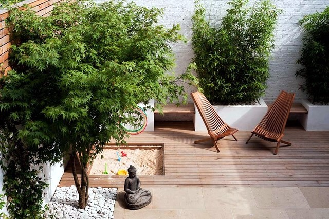 A tranquil backyard retreat with a wooden deck and tree, designed for comfort and connection.