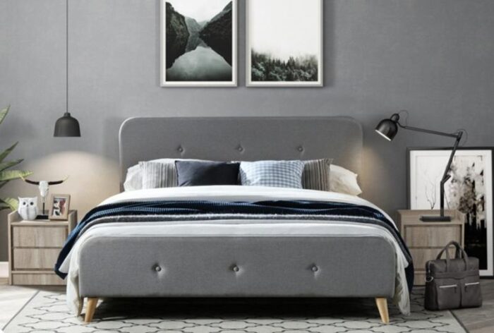 A modern bedroom with a comfortable grey bed.