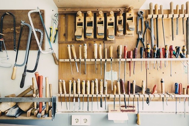 Woodworking tools on a wall in a workshop with tips for organizing.