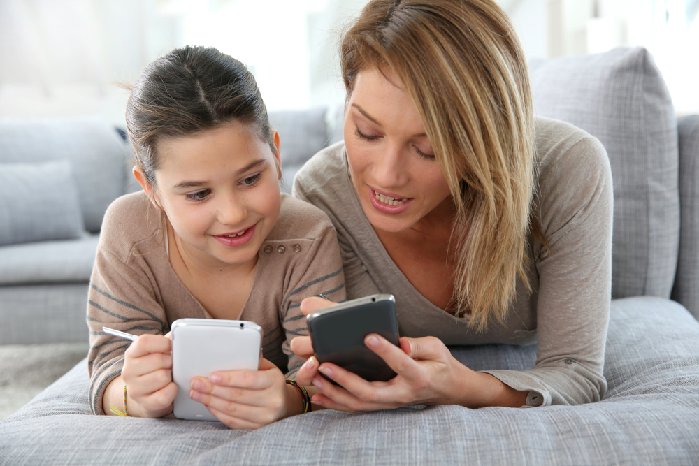 A mother and daughter laying on a couch, emphasizing the importance of phone tracking.