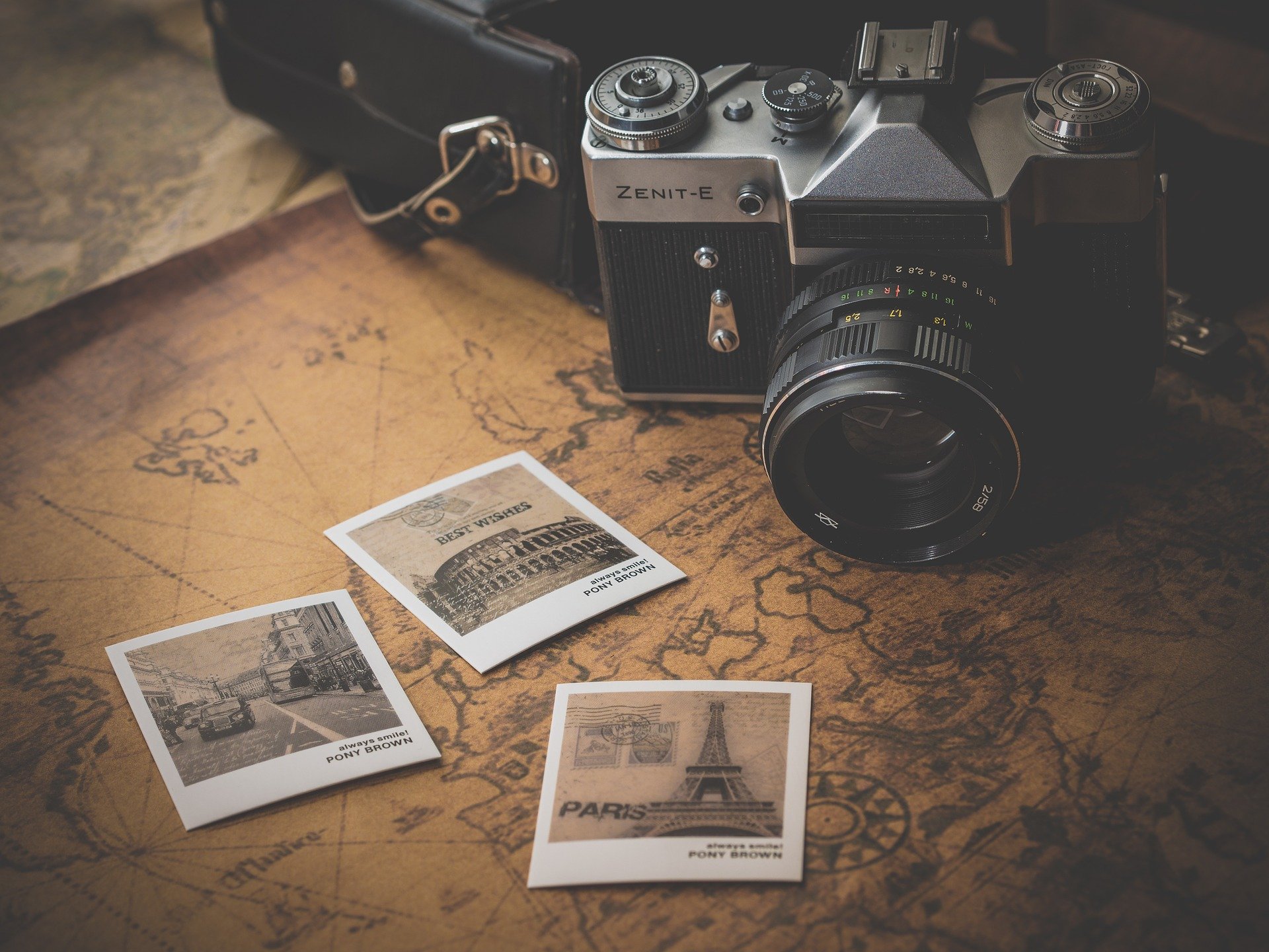 A map and photos on a table demonstrate tips for organizing old photos.