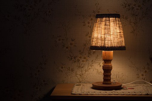 Three wooden table lamps make a design statement in a dark room.