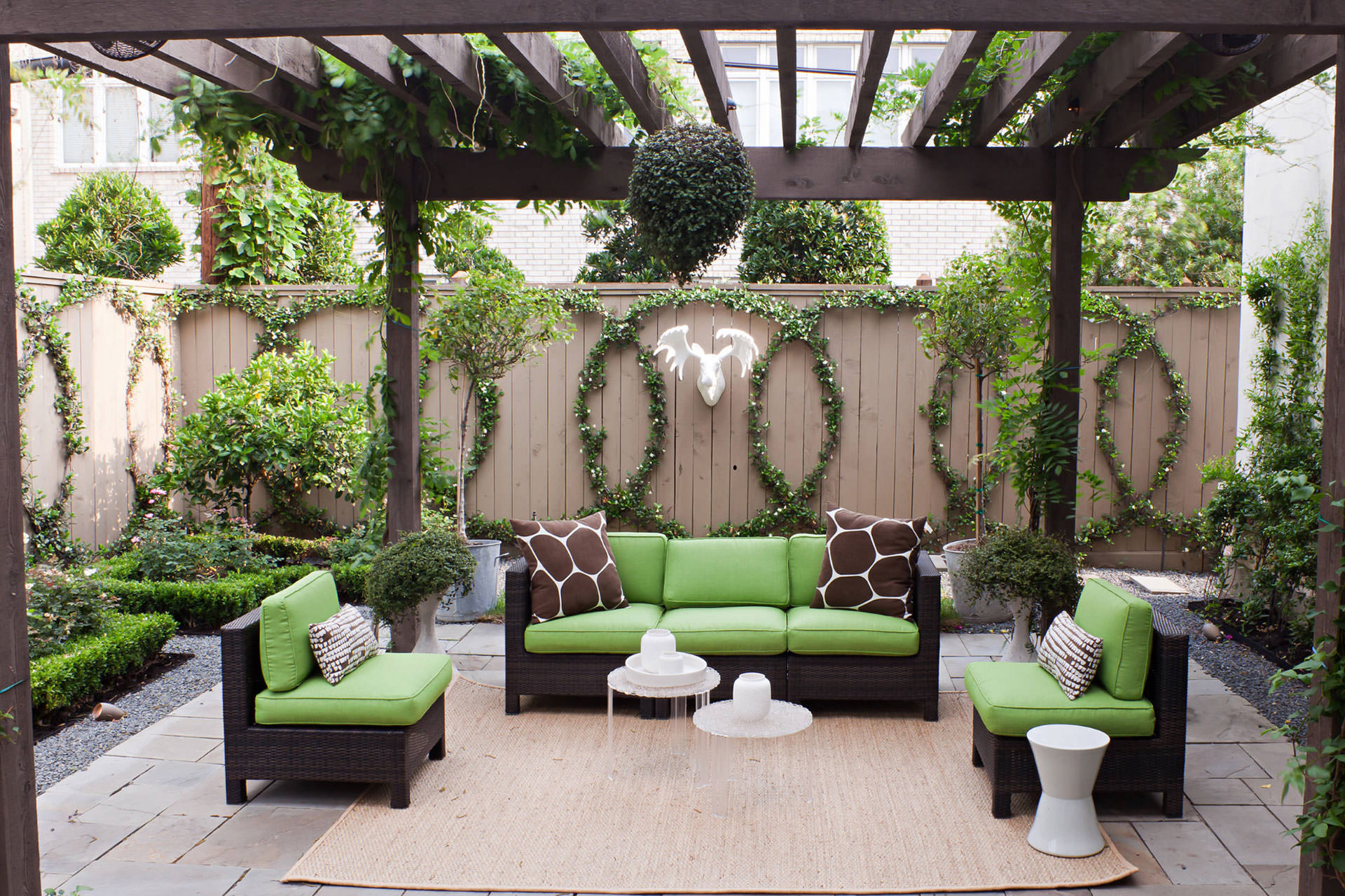 An outdoor space with green furniture and a pergola.