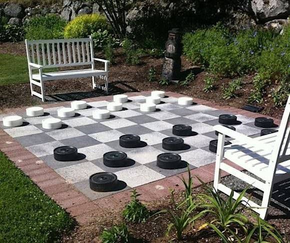 Landscaped garden with a chess board and seating options.