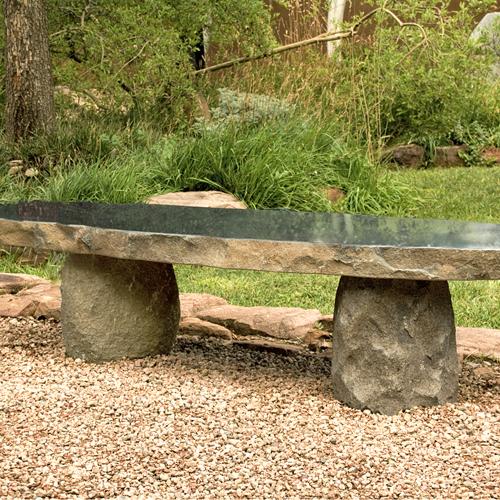 A large stone bench in a garden.