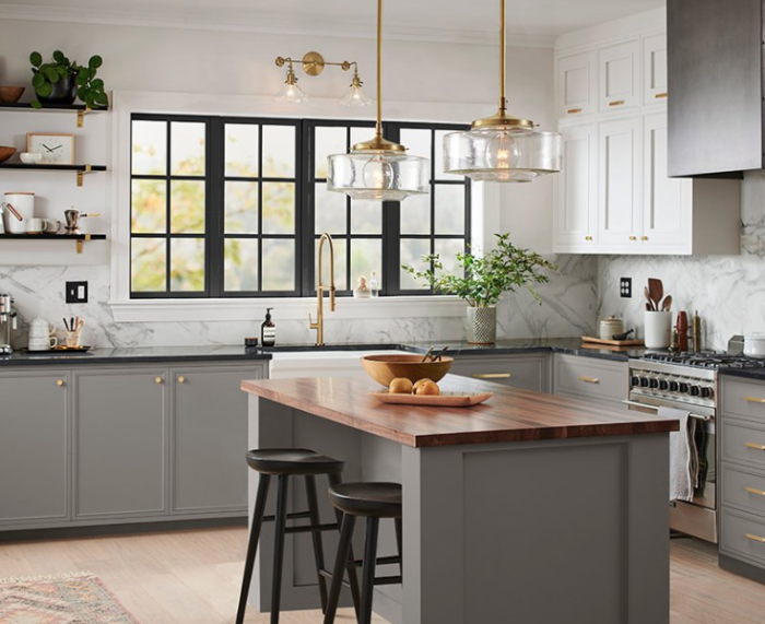 A kitchen design with a gray island and stools.