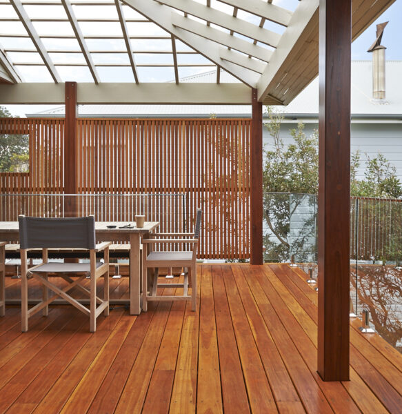 A landscaped wooden deck featuring a table and chairs.