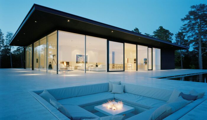 A fire pit integrated with architectural glass in the middle of a house.