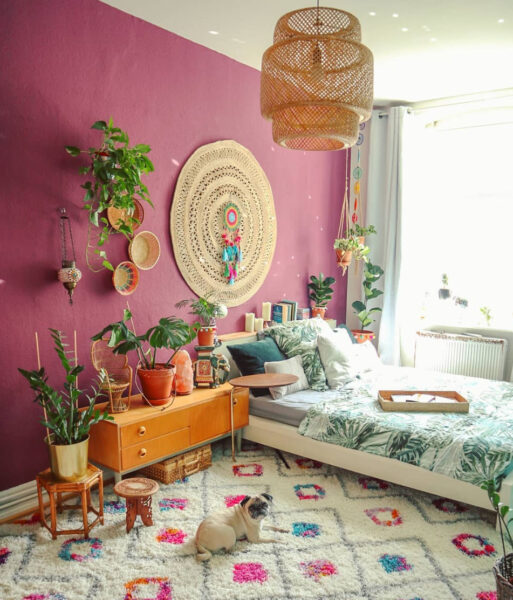 A boho bedroom with a dog on a rug.