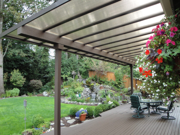 A covered outdoor space with a table and chairs.