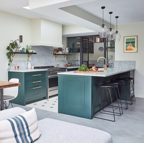 A kitchen with a green cabinet design and a white island.