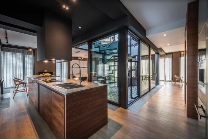A kitchen with glass doors and a wooden floor made of natural materials.