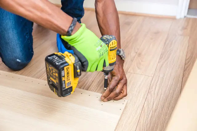 A man using a drill to renovate a starter home.