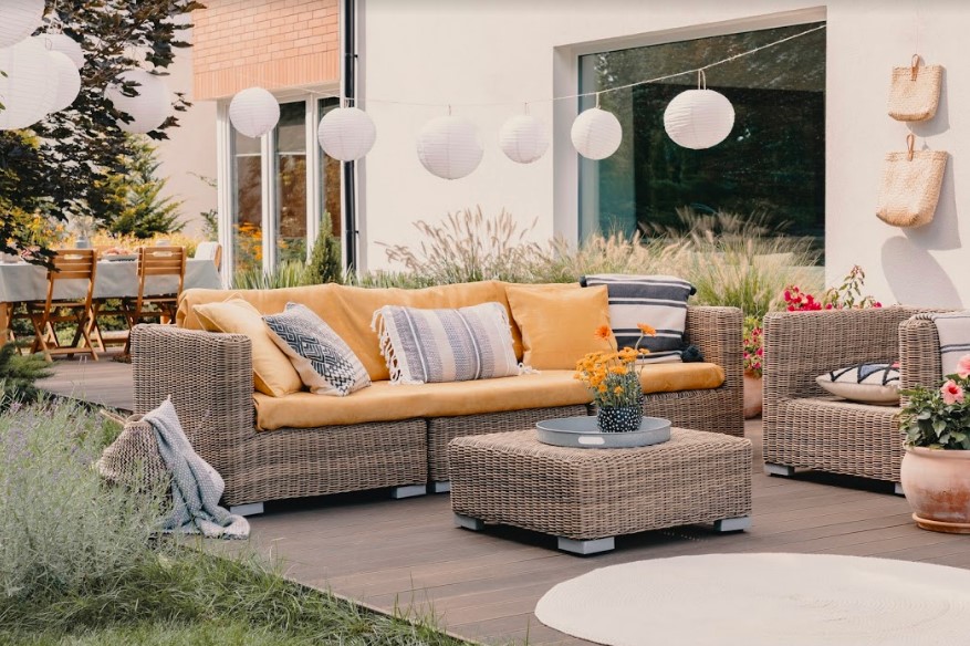 Garden furniture with yellow pillows on a patio.