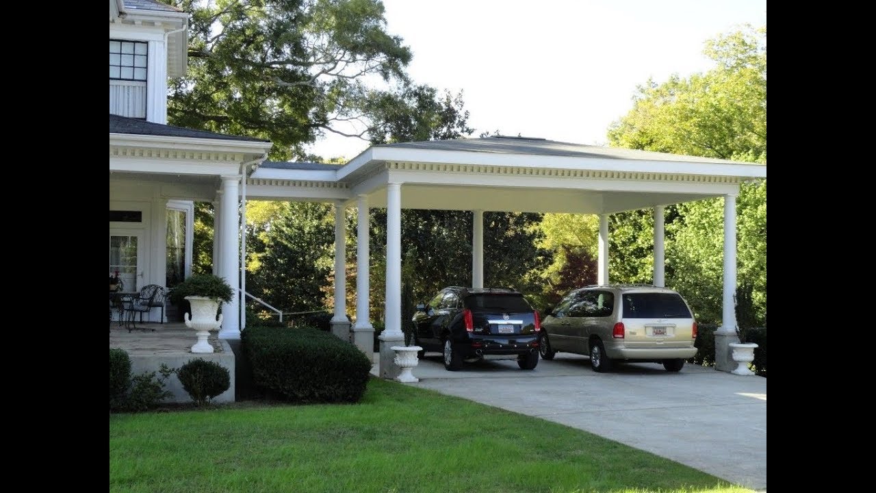 A car is parked in front of a house with a carport. (Keywords: House, Carport)