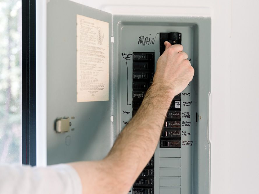 A man installing a circuit breaker in a home.
