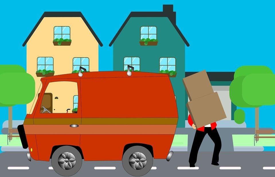 A man moving out, carrying a box in a moving truck.