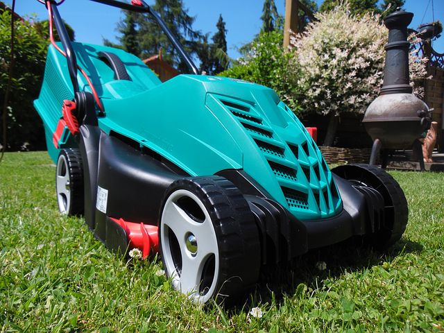 A lawn mower is parked on the grass.