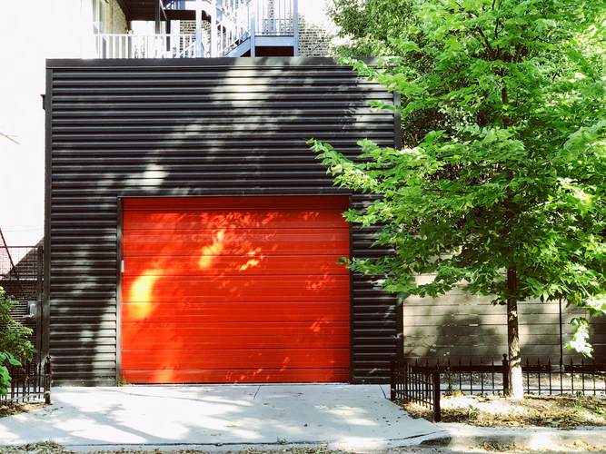 A black garage door with an orange door.