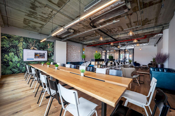 An office with a long wooden table and chairs that is both fun and professional.