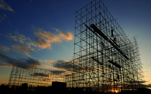 A silhouette of a construction site featuring scaffolding.