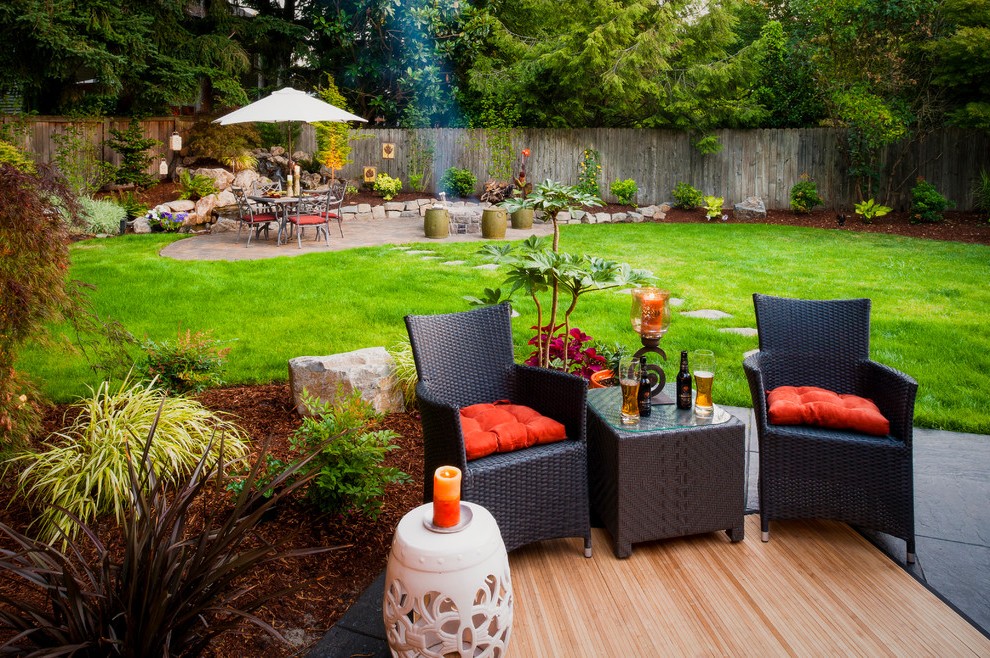 An outdoor living space with wicker furniture and an umbrella.