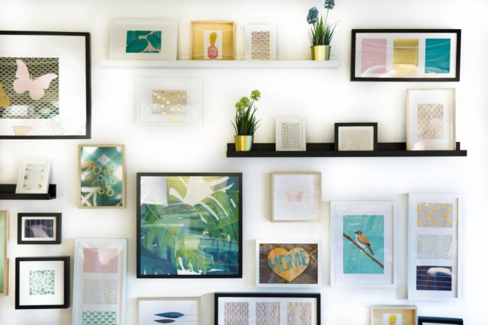 A wall adorned with framed pictures and eco-friendly plants, perfect for a redecorating project.