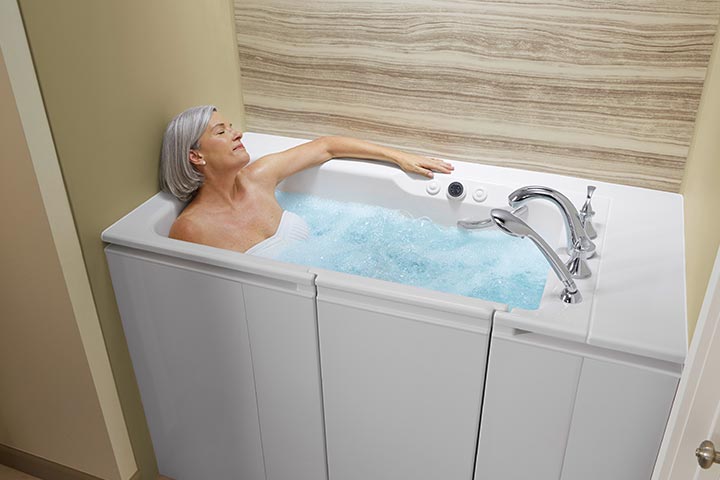 A woman is relaxing in a walk-in tub in a bathroom.