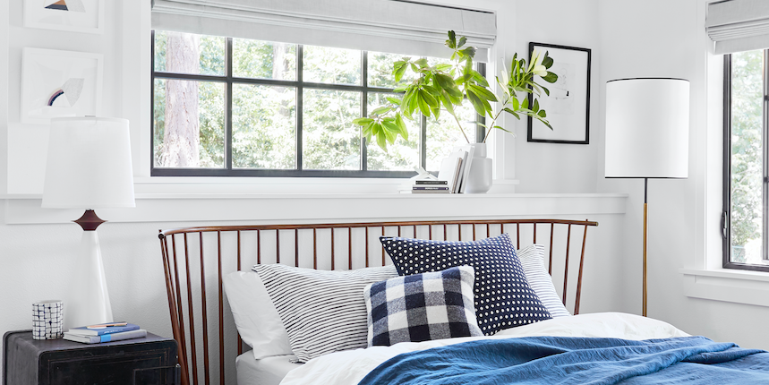 A bedroom with a bed and a bedside table, enhanced by three of the best plants for your space.