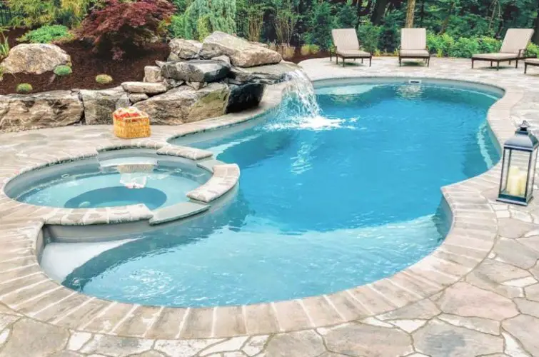A backyard renovation featuring a swimming pool with a waterfall.