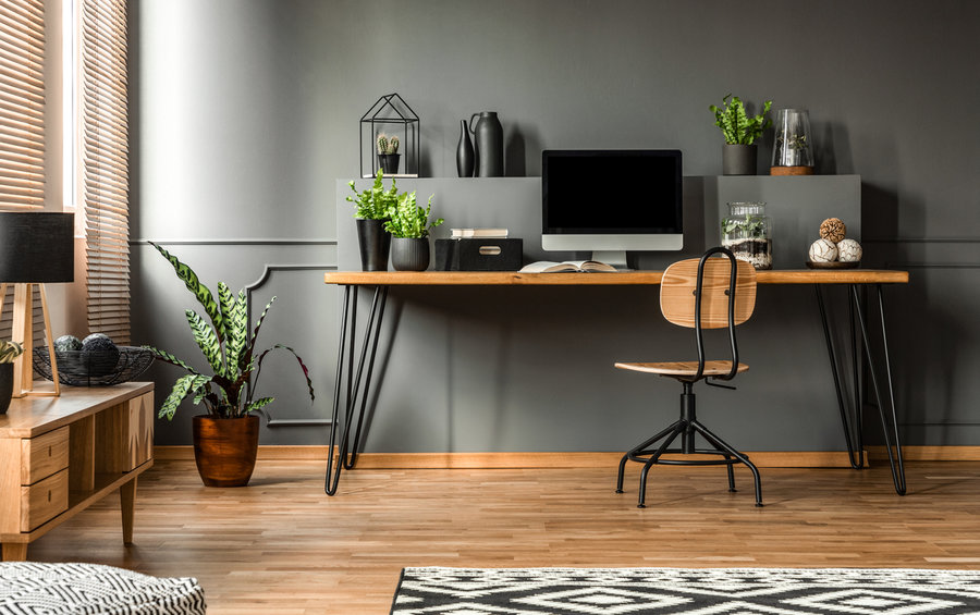 A modern office with black walls and a black desk.