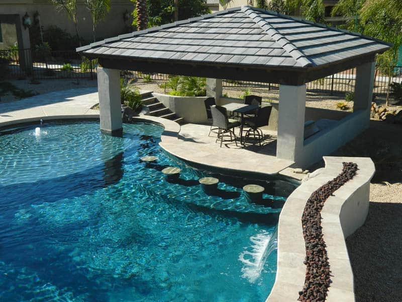 A swimming pool with a gazebo and patio transformed into a pool bar.