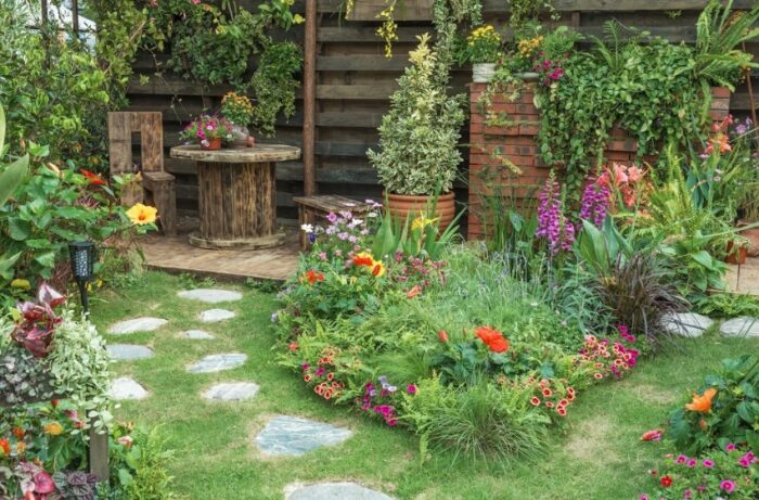 A garden with a stone path and an abundance of flowers.