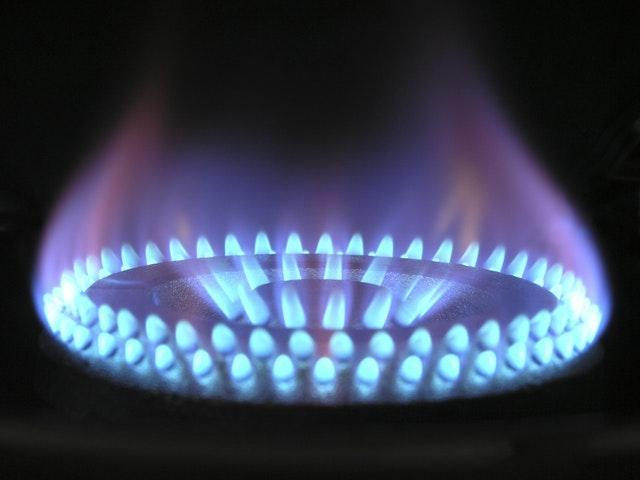 A close up of a gas stove with blue flames during a gas heater service.