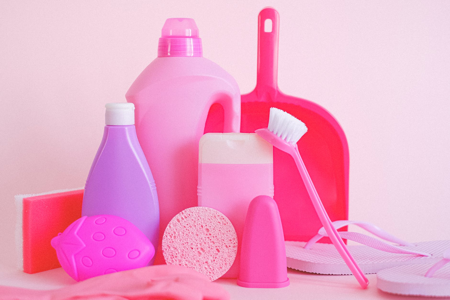 Pink home cleaning products on a white background.
