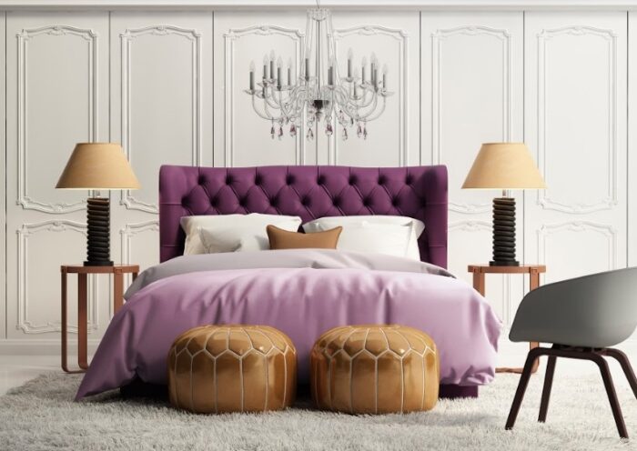 A luxurious bedroom featuring a purple upholstered bed and a chandelier.