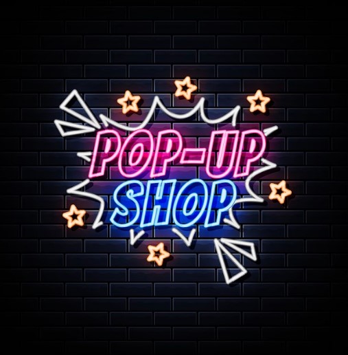 Neon pop-up shop sign on a wall.