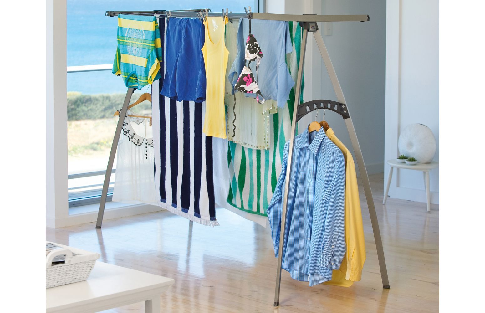 An indoor room with clothes hanging on a portable clothes line.