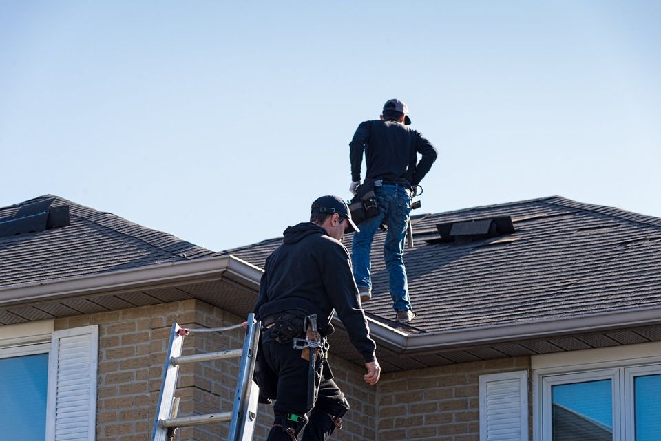 Two men repairing a roof.