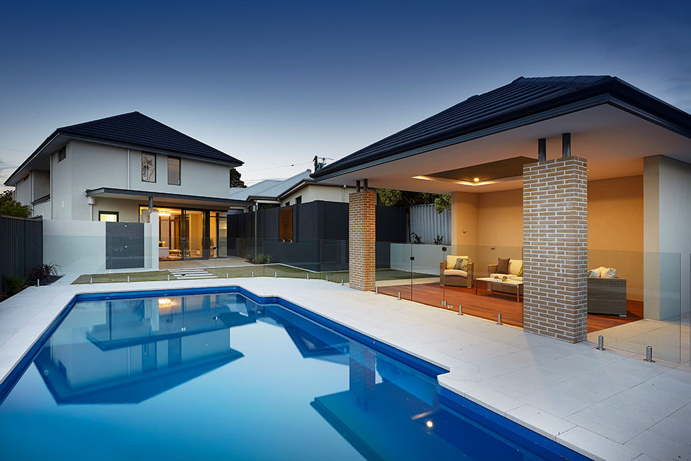 A house with a swimming pool and Bluestone Pavers in the backyard.