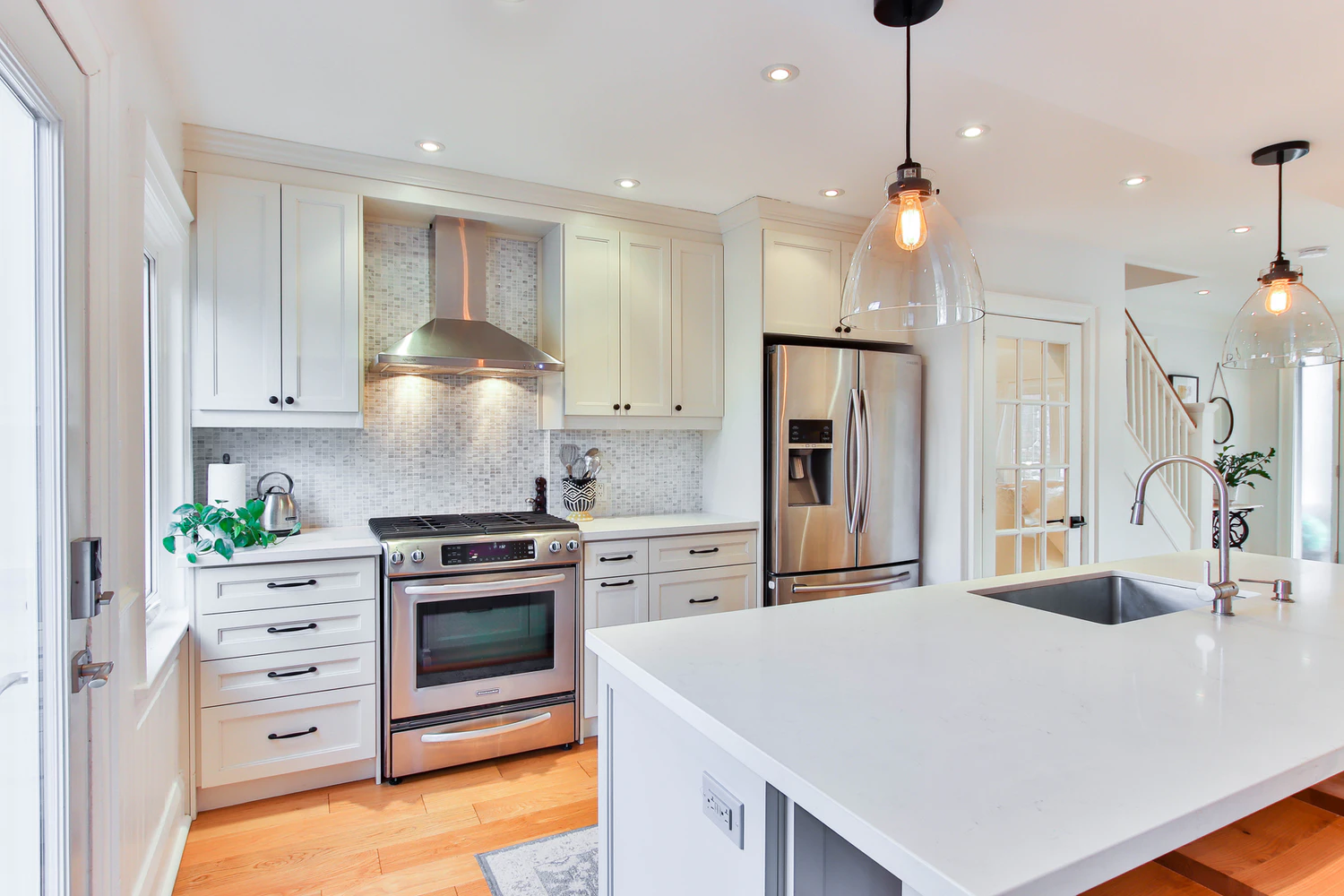 A white kitchen with stainless steel appliances featuring 12 awesome renovation updates.