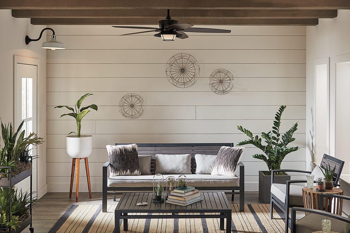 A living room with a ceiling fan.
OR
A living room with wicker furniture.