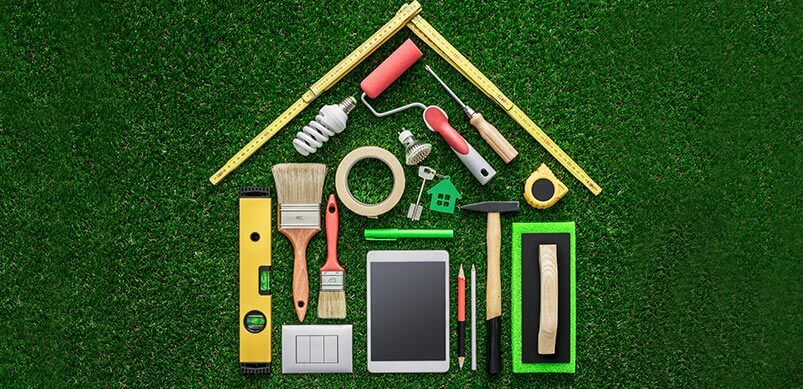 A DIY-inspired house with tools in the shape of a home on grass, highlighting the pros and cons of DIY.
