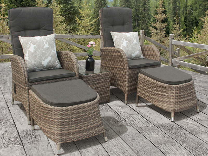 A garden lounge set with rattan chairs and cushions on a wooden deck.
