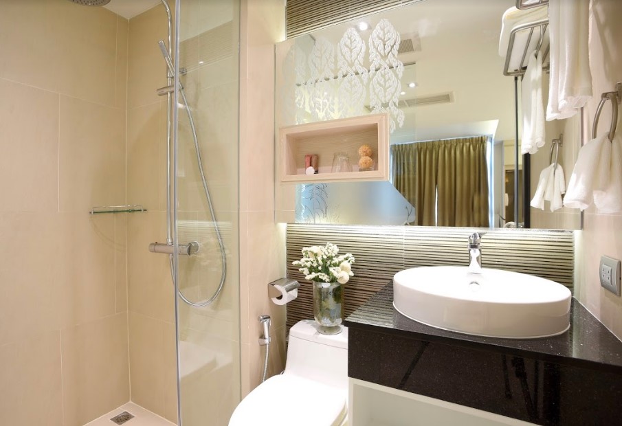 A small bathroom with a glass shower stall and toilet.