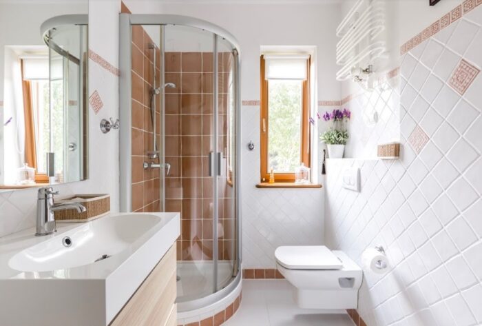 A compact bathroom with a toilet, sink and shower.