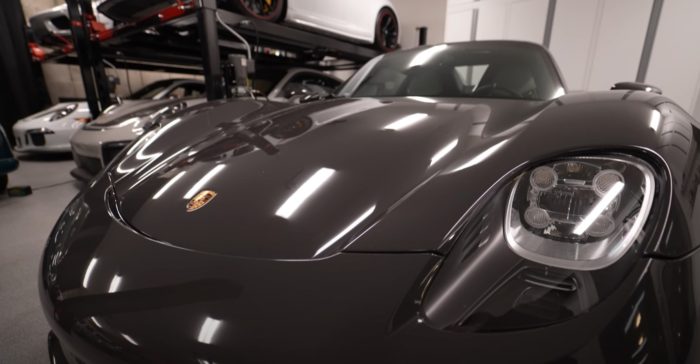 A black porsche sports car is parked in a garage.