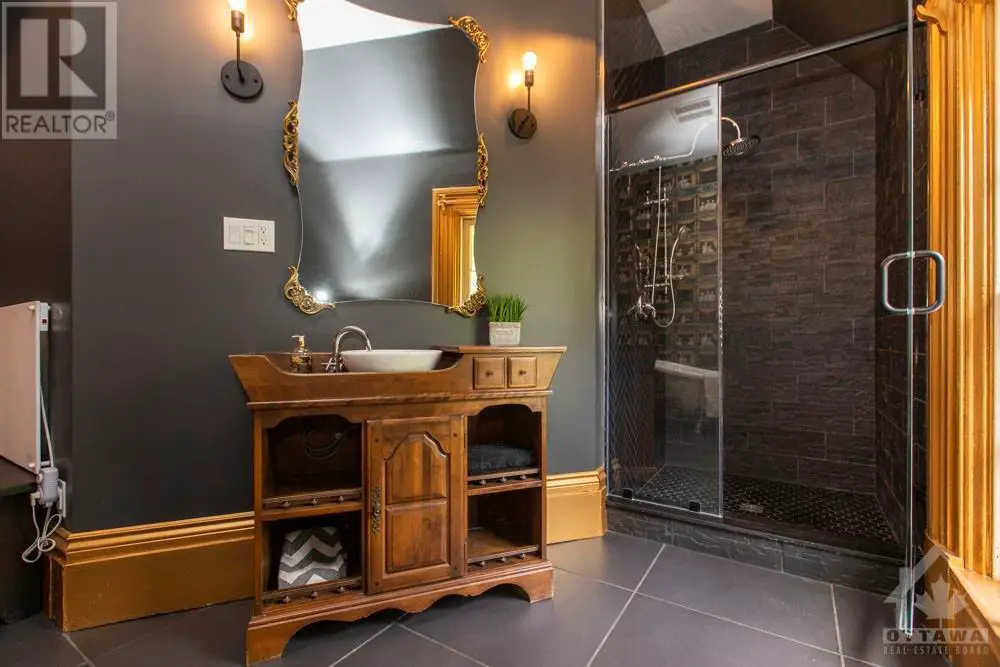 A Victorian-inspired bathroom with black walls and a wooden vanity.