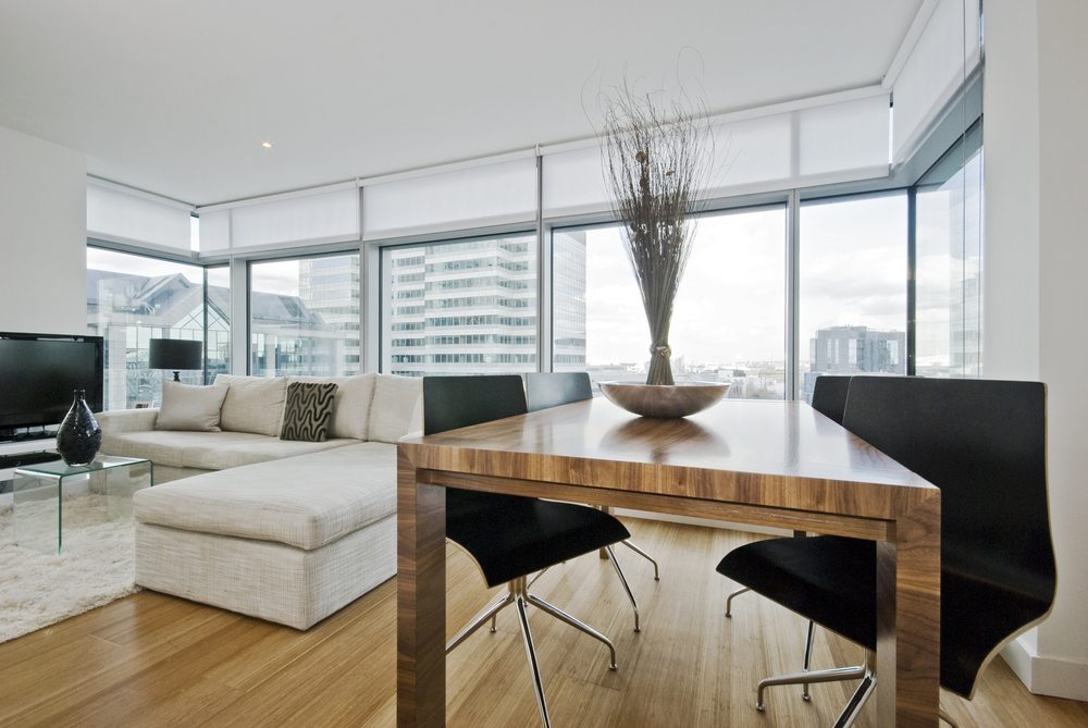 A living room with a best custom window treatment and a view of the city.