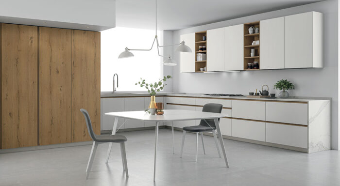 A trendy kitchen design with a white and wood theme, featuring a table and chairs.